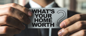 Whats Your Home Worth? man holding small sign appraisal icons with home, graph, checklist and calculator